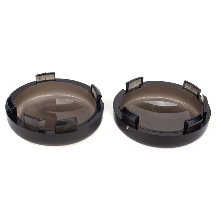 Two black smoked motorcycle turn signal cover shells with top openings and clips