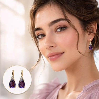 Women’s teardrop dangle earrings with purple crystal stones and gold-tone hooks.