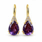 Gold-tone teardrop earrings with faceted purple crystal drops and clear sparkle accents.