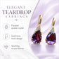 Teardrop dangle earrings featuring purple faceted crystals with gold-tone hook and clear stones.