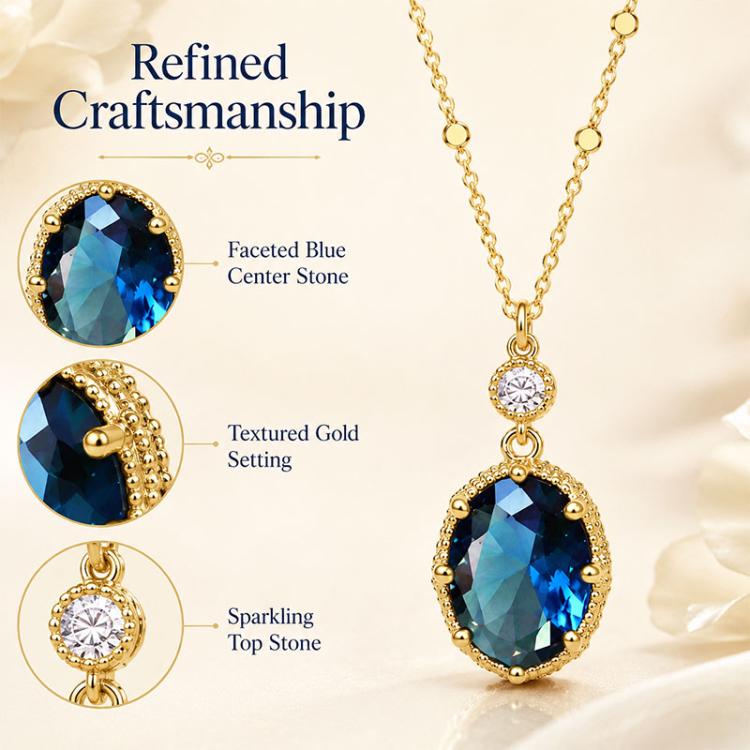 Gold-tone pendant with faceted oval blue center stone and clear round top