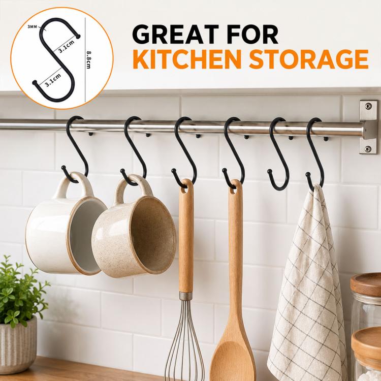 Black iron S-shaped hooks on metal rail, holding mugs, utensils, and towels