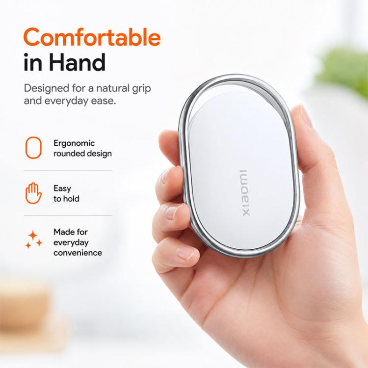 Xiaomi wireless smart tracker tag held in hand, white oval with silver rim