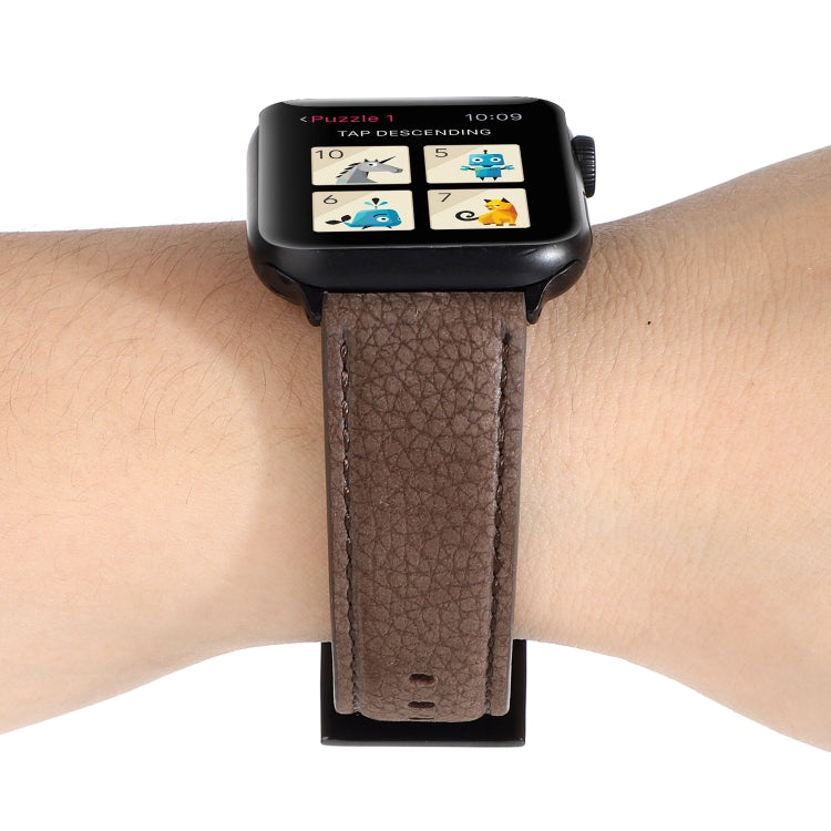 Brown litchi-textured genuine leather watch band on wrist, with metal clasp