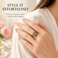 Pink gemstone and green enamel leaf ring worn on finger, gold-tone setting