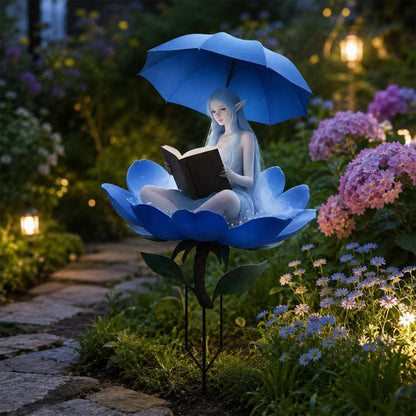 Decorative garden stake with blue flower, fairy reading book under umbrella