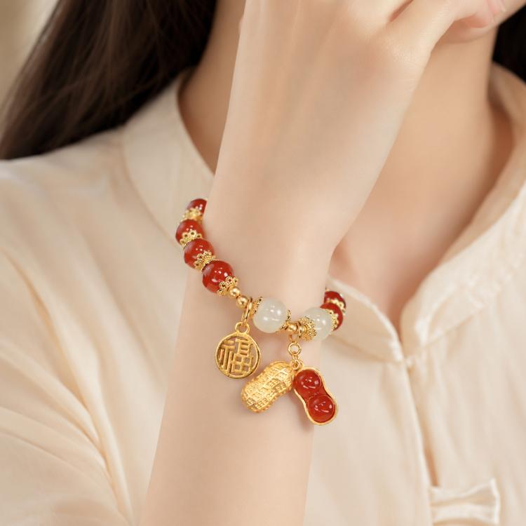 Women’s red bead peanut charm bracelet with gold-tone coin, peanut, and white beads