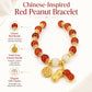 Red beaded peanut charm bracelet with gold-tone charms and white bead accents