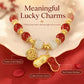 Lucky peanut charm bracelet with red beads, gold pendants, and white center bead