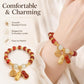 Red bead peanut charm bracelet on wrist with gold-tone coin and peanut pendants