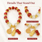 Beaded peanut charm bracelet with red beads, white spacers, and gold-tone charms