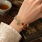 Peanut charm bracelet with gold chain and red peanut and bead charms
