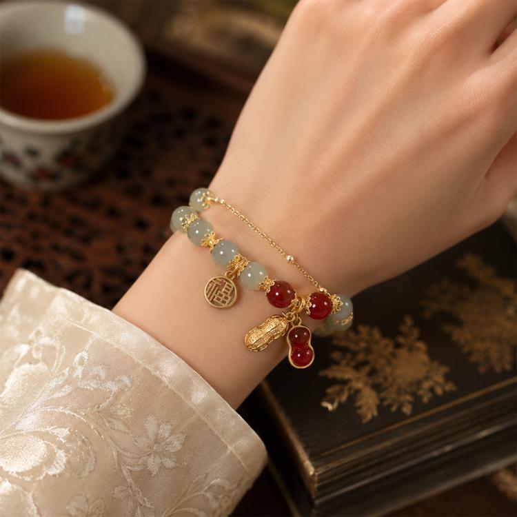 Peanut charm bracelet with gold chain and red peanut and bead charms