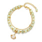 Women’s gold beaded charm bracelet with pale green beads and a teardrop leaf pendant.