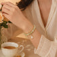 Gold-tone charm bracelet with pearl-like beads and dangling heart charm