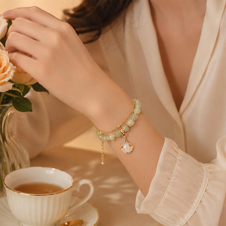 Gold-tone charm bracelet with pearl-like beads and dangling heart charm