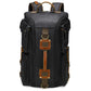 Black canvas travel backpack with top handle, side pockets, and front leather strap detail