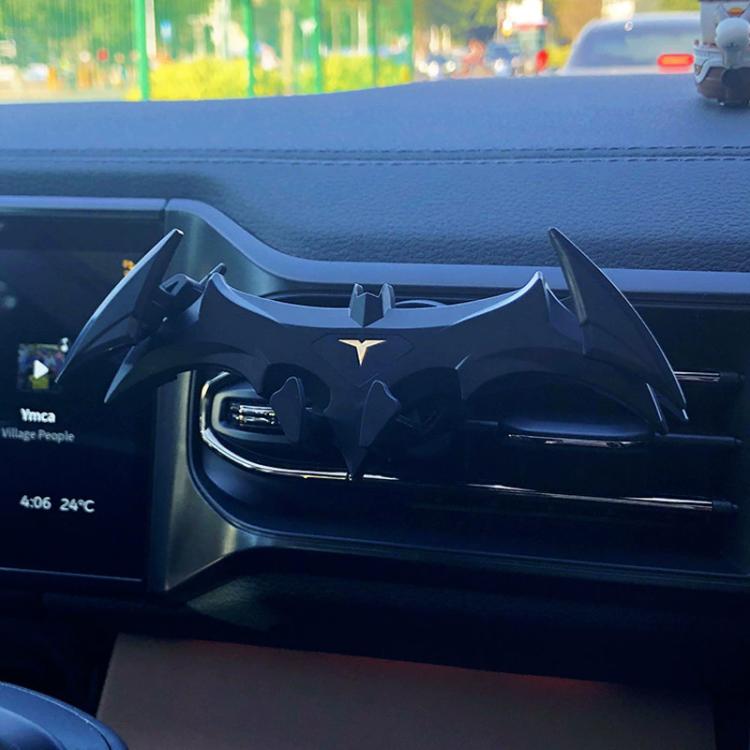 Bat-style car phone mount attached to air vent, black design with yellow emblem