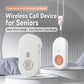 White wireless call receiver and handheld call button on a table near a bed