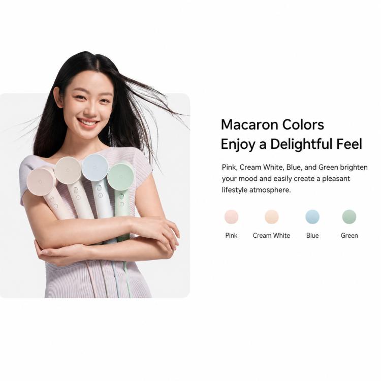 Pastel color hair dryer with round nozzle and front vent, held in hand
