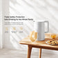 White electric kettle on a wooden table with a cup and snacks nearby.