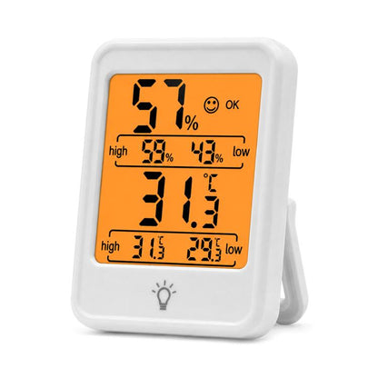 White digital thermometer and hygrometer with backlit orange display showing 57% and 31.5