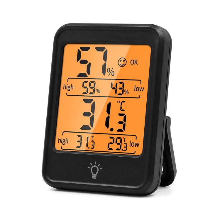 Black digital thermometer and hygrometer with backlit orange display showing 57% and 31.5