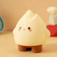 Beige flame night light with tiny closed-mouth smile and round cheeks