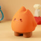 Orange flame night light with small winking eyes and round cheek dots