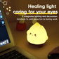 Yellow glowing flame night light on a desk with cute face and round cheek dots