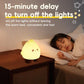 Yellow glowing flame night light with small cute face on bedside table