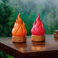 Pair of LED simulated flame lamps in orange and red on tan round bases