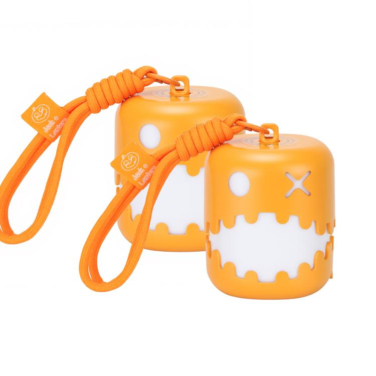 Two orange pumpkin lantern night lights with jack-o'-lantern faces and straps.