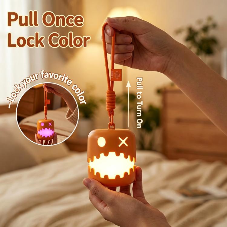 Orange pumpkin lantern night light with pull handle and jack-o'-lantern face.