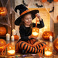 Orange pumpkin lantern night light with jack-o'-lantern face, held by child.