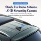 Shark-fin antenna mounted on car roof with compact camera housing