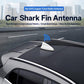 Gray shark fin car antenna mounted on a vehicle roof