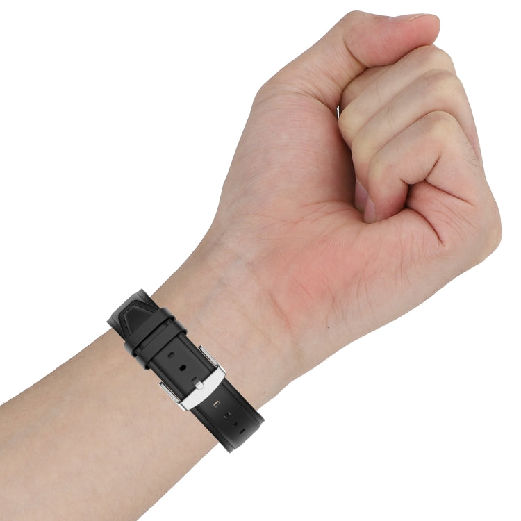 Black 20mm watch strap on a wrist with metal buckle and adjustment holes