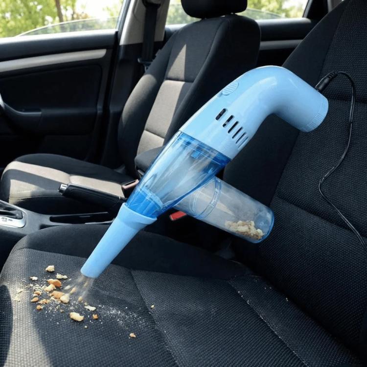 Handheld blue dust cleaner in a car seat, removing small debris from fabric