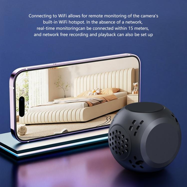 Black mini security camera on desk beside a smartphone for remote viewing