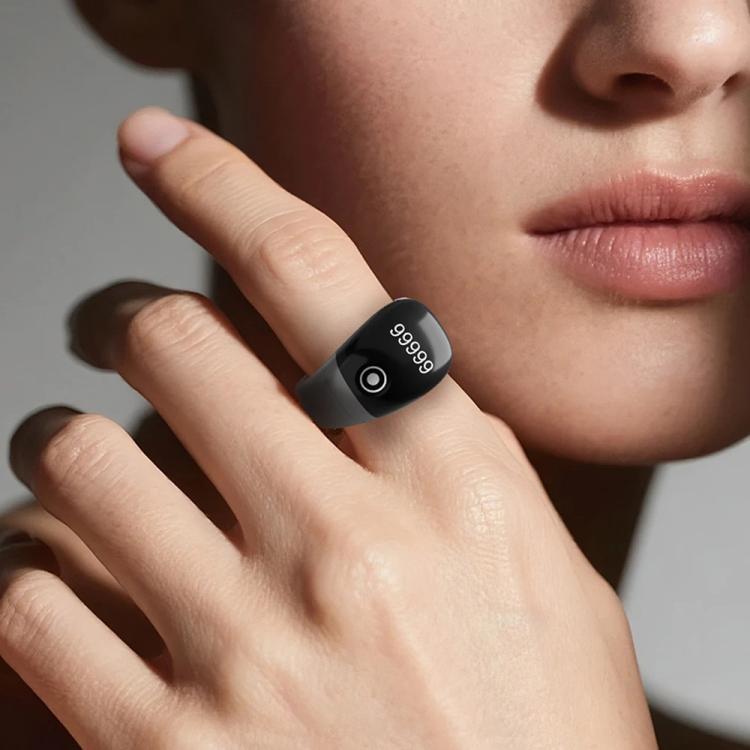 Black smart counting prayer ring worn on finger, round touch button visible
