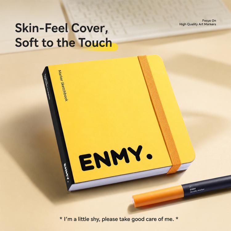 Yellow ENMY square sketchbook with soft-touch cover, orange marker beside