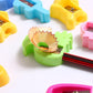 Close-up of green single-hole pencil sharpener with exposed blade and shavings