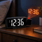 Black LED projection alarm clock on desk with orange projected time