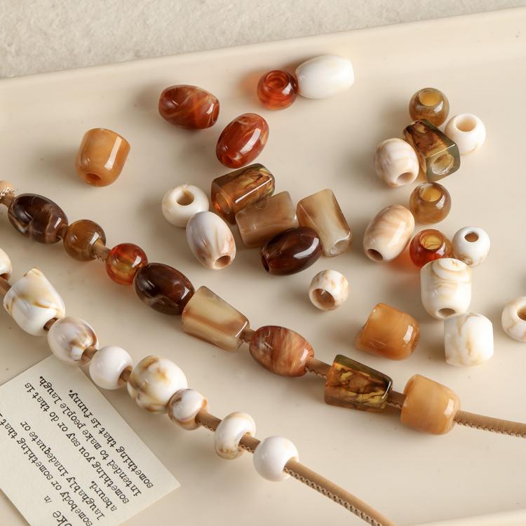 Large-hole acrylic beads, marbled amber and white, strung along a beaded cord