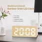 Bamboo-grain LED clock displaying time digits with brightness icon on pink frame.
