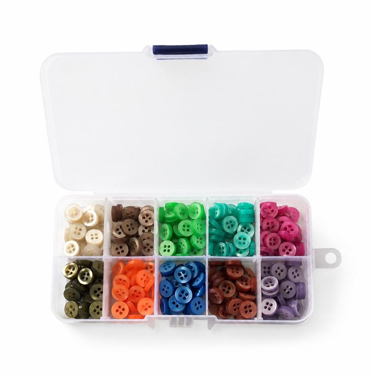 Mixed-color four-hole resin buttons in open case, separated into color sections