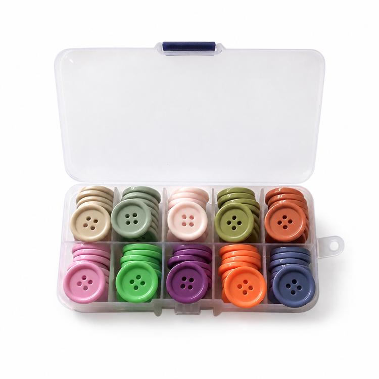 Mixed-color four-hole resin button set in open organizer with layered color rows