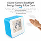 Blue square desktop alarm clock with digital display and hand near the screen