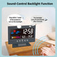 Black LCD weather clock showing time; clap-activated auto backlight indicator lines.